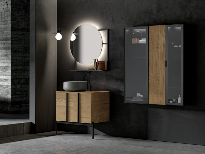 Bagno in essenza rovere naturale, lavabo in ceramica grigio oliva opaco, basamento, telaio e maniglia in metallo nero, ante in vetro trasparente grigio