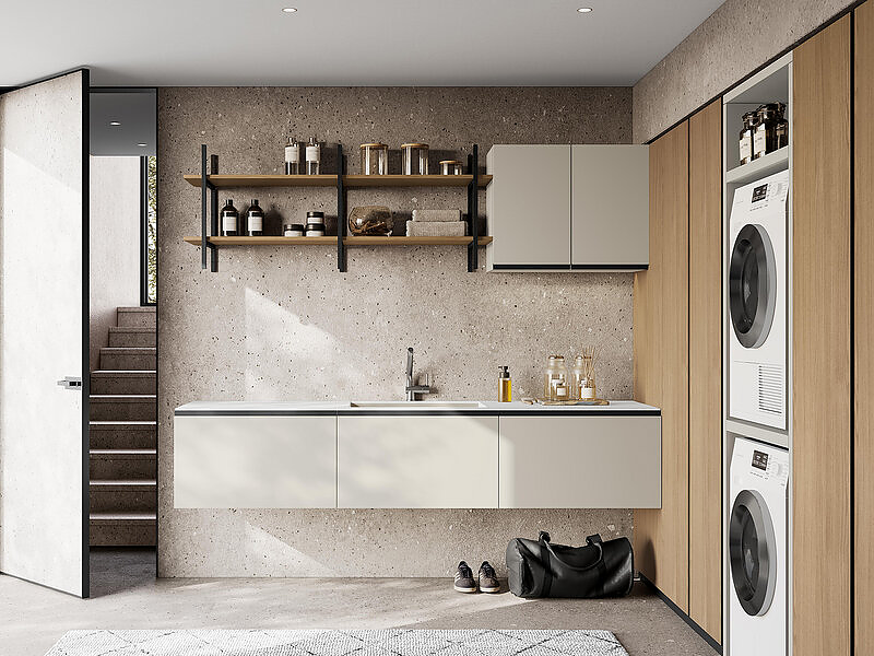 Pensili e basi sospese con gola in laccato opaco light grey con piano intergrato in marmo minerale bianco opaco.  Scaffalatura in metallo e materico rovere Virginia. Colonne materico rovere Virginia con elemento portalavatrice laccato opaco light grey.