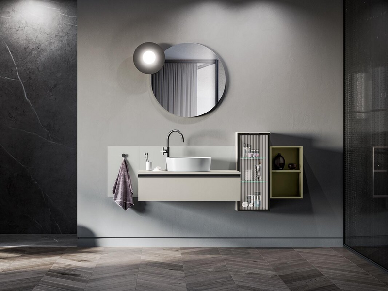 Bagno in laccato effetto cemento perla, vano a giorno in laccato opaco verde malva, anta in vetro canneté, schiena in Fenix NTM grigio Efeso, telaio e maniglia in metallo nero