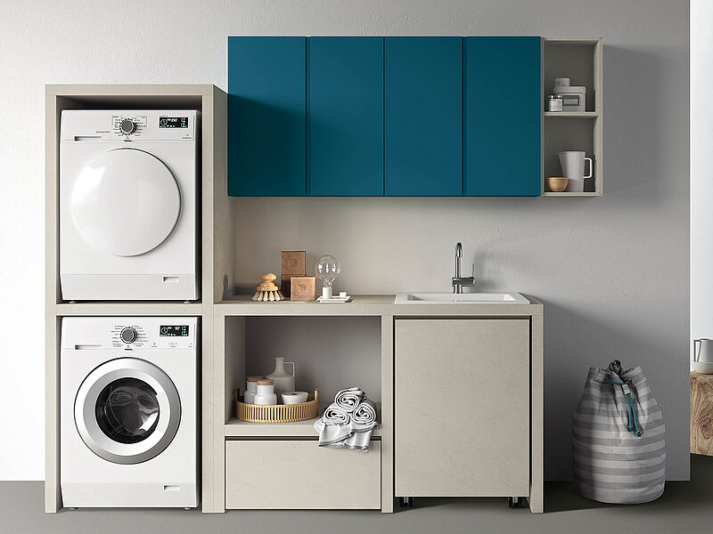 Elementi a giorno con cestoni e modulo portalavatrice e asciugatrice in materico perla. Pensili laccato opaco blu oceano.