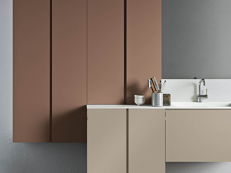 Basi laccato opaco corda con piano e vasca integrata in marmo minerale e pensili in laccato opaco terracotta.